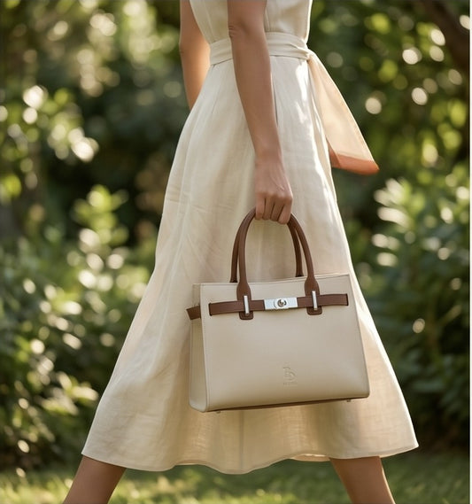 Lifestyle shot of a woman holding the luxury tote bag while walking in a garden.